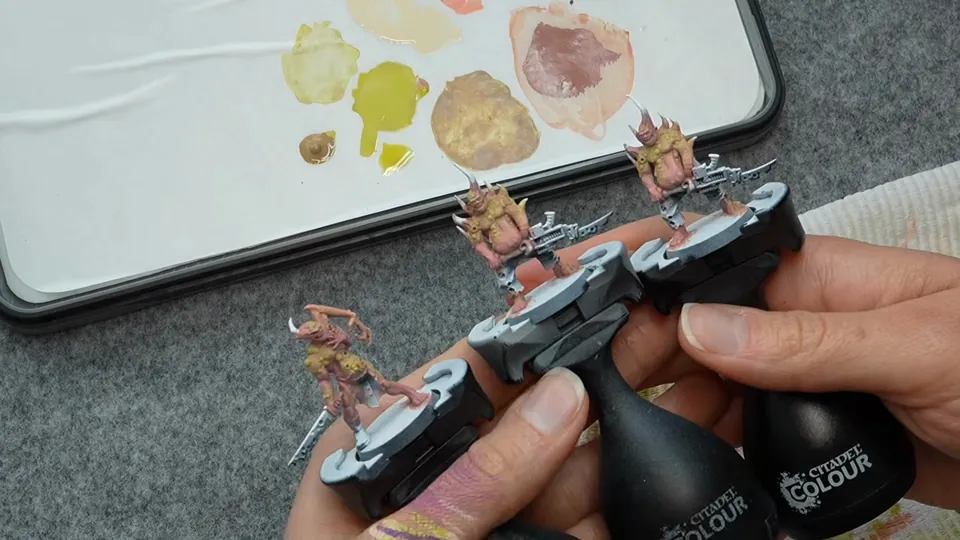 Three miniatures on painting handles held over the palette, Episode 05