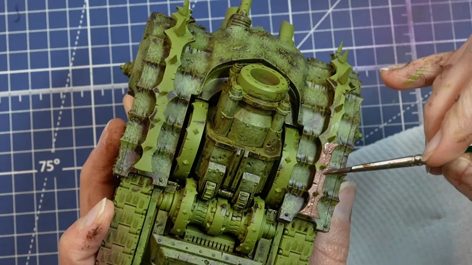 Base coating the copper trim with a fine brush over the green armour of her Death Guard tank, Episode 07