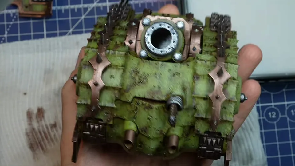 The tank hull from above with its silver exhaust ring and copper trims finished, held in her palm, Episode 07