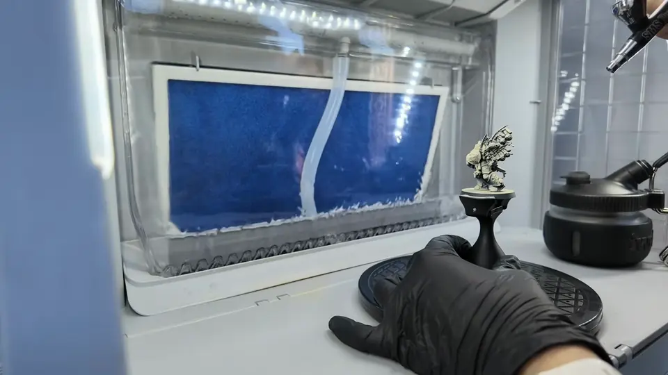 The assembled Biologus Putrifier on a painting handle inside her spray booth, airbrush in hand, Episode 02