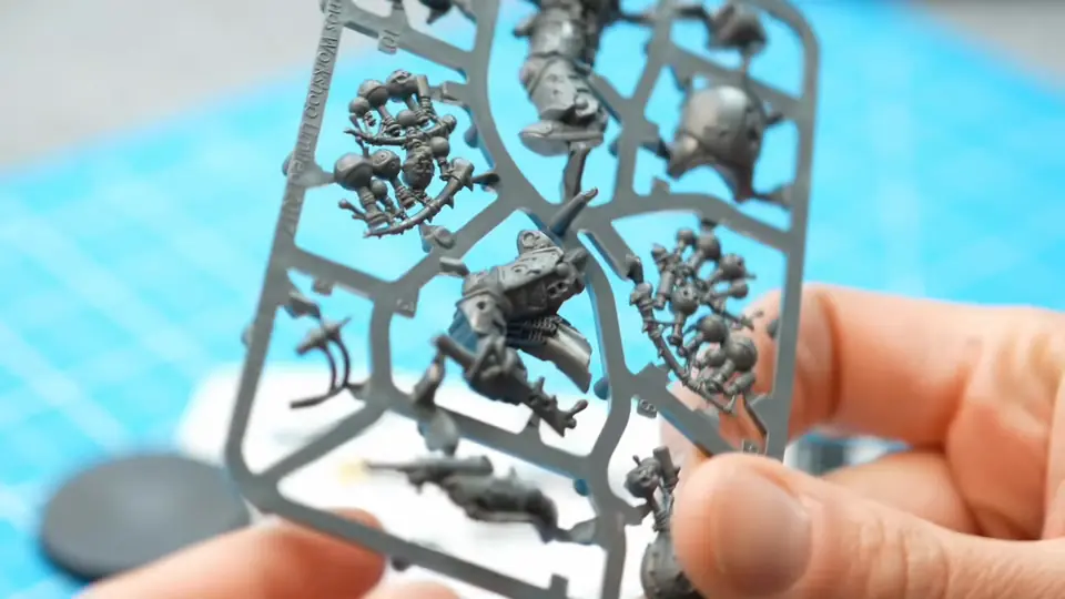 The Biologus Putrifier parts still on the grey plastic sprue, held up over the cutting mat before any clipping, Episode 02